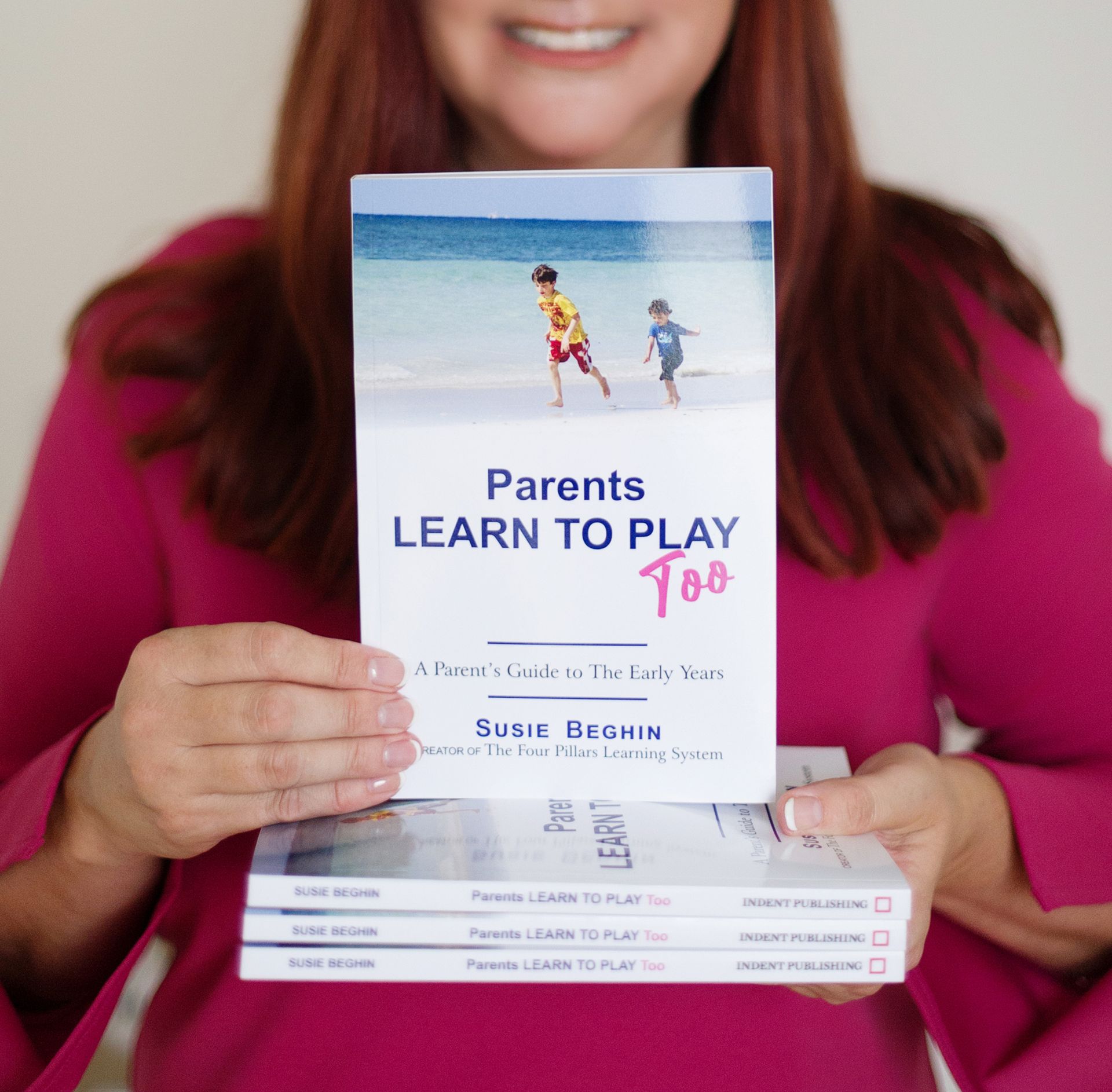 Susie holding her book, Parents Learn to Play Too.