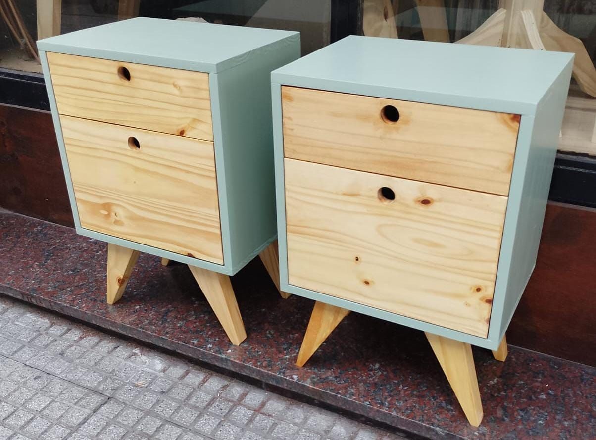 Dos mesitas de noche de color azul claro con dos cajones de madera cada una, colocadas sobre patas de madera en ángulo.