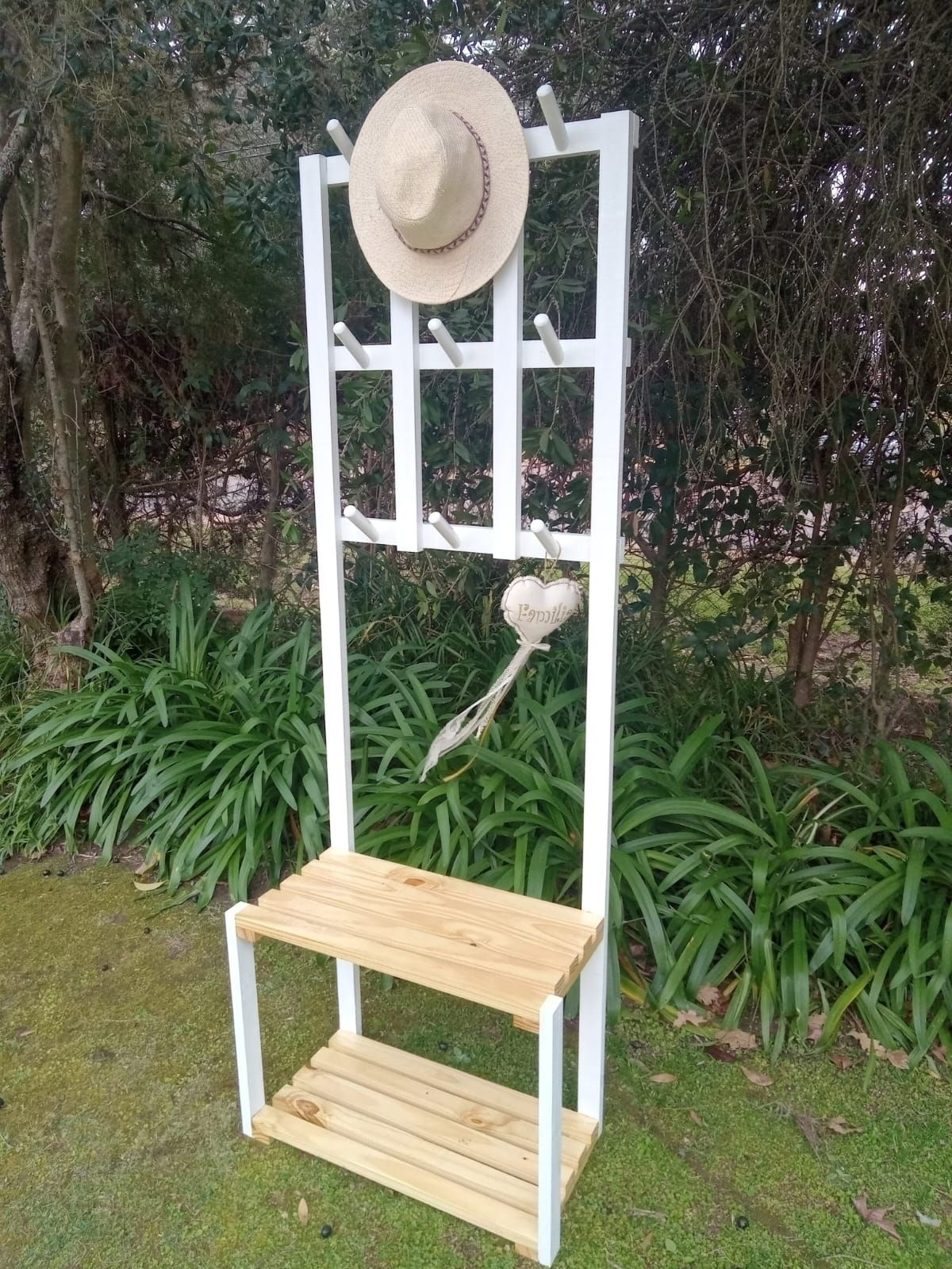 Perchero de madera blanca con banco, sombrero y ganchos para exterior.