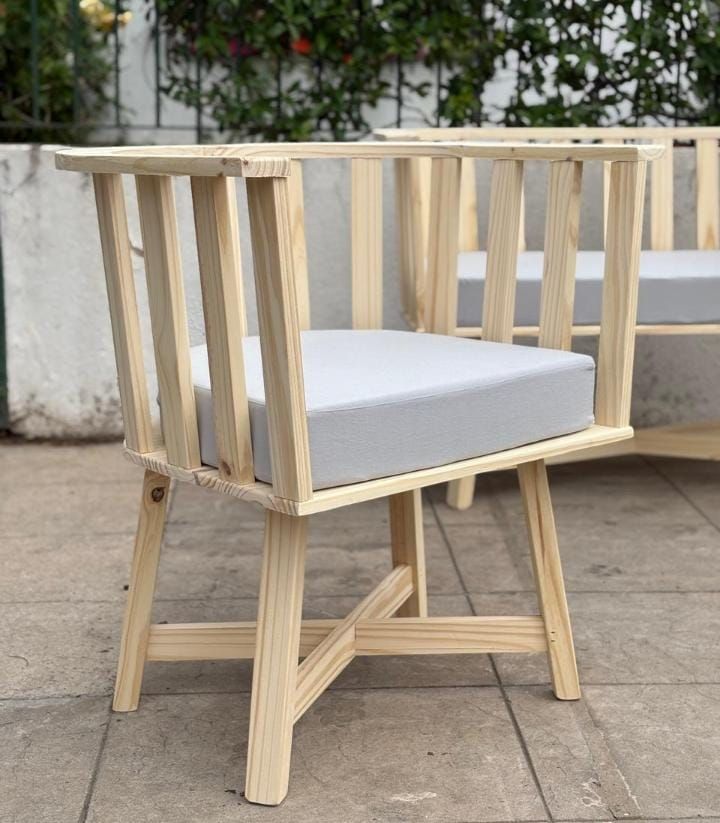 Silla de madera con cojín gris claro, en un patio.