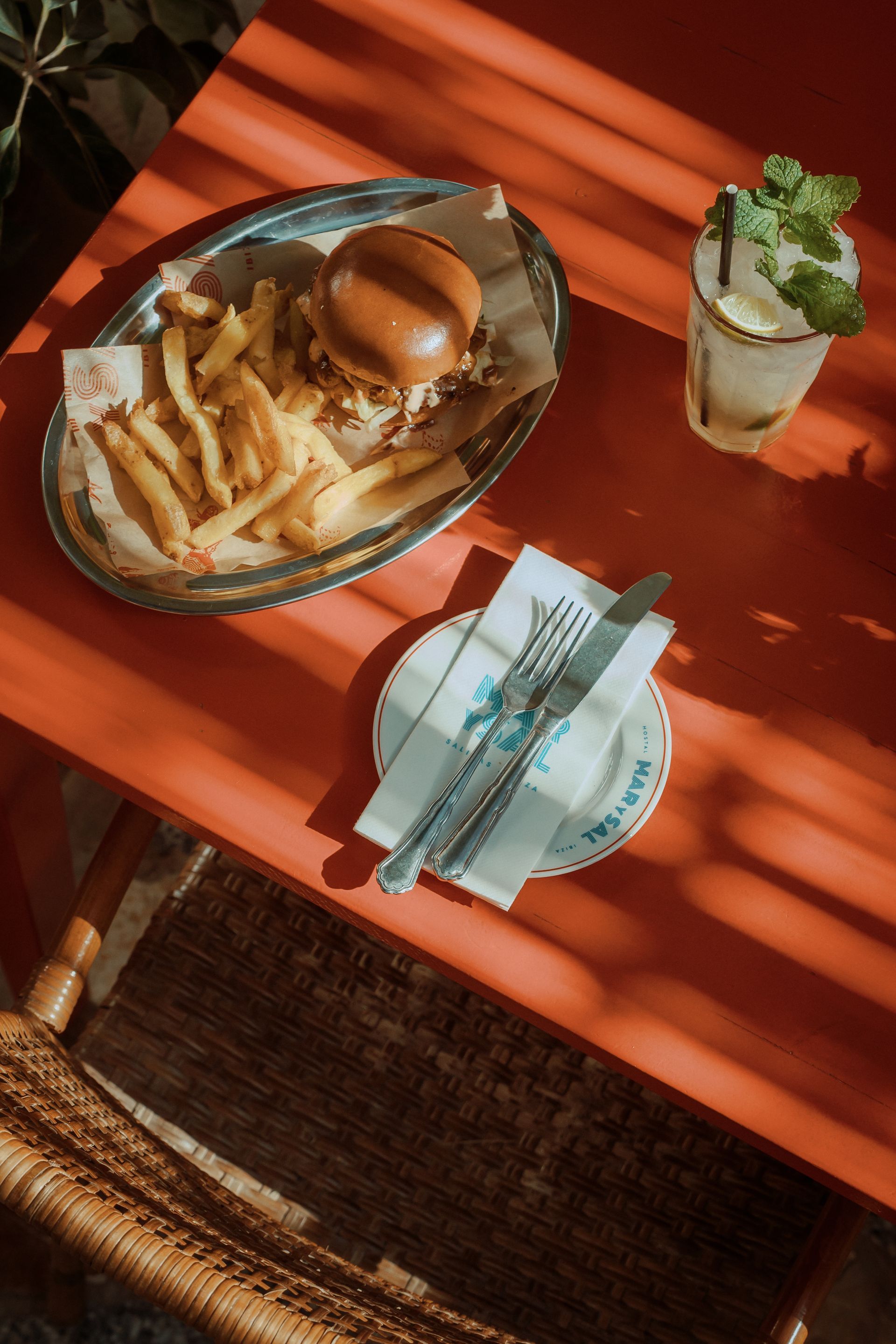 A plate of food with a hamburger and french fries on a table.