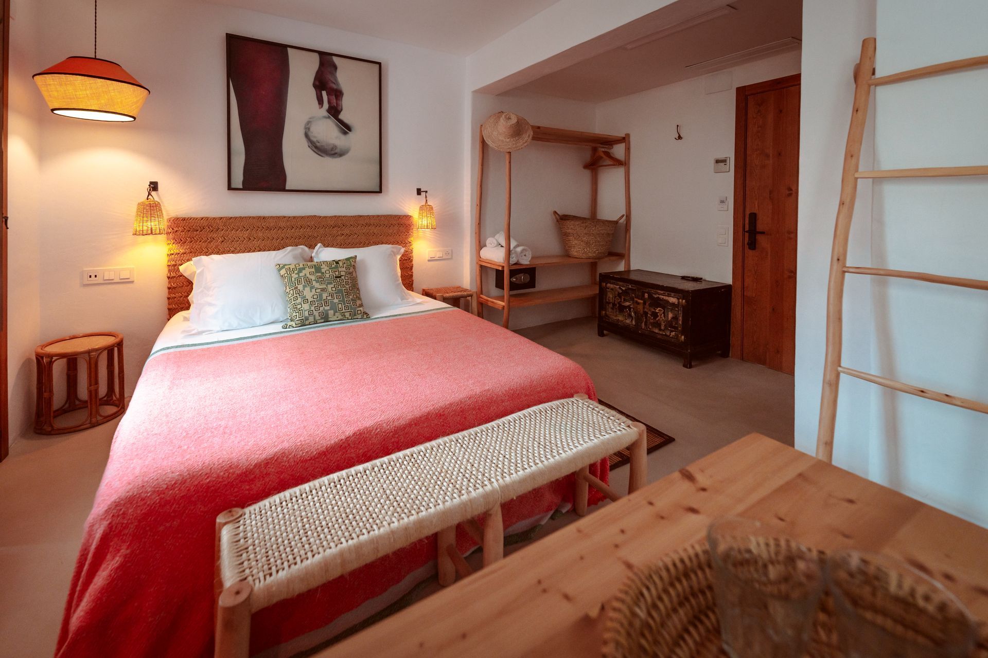 A bedroom with a large bed and a bench