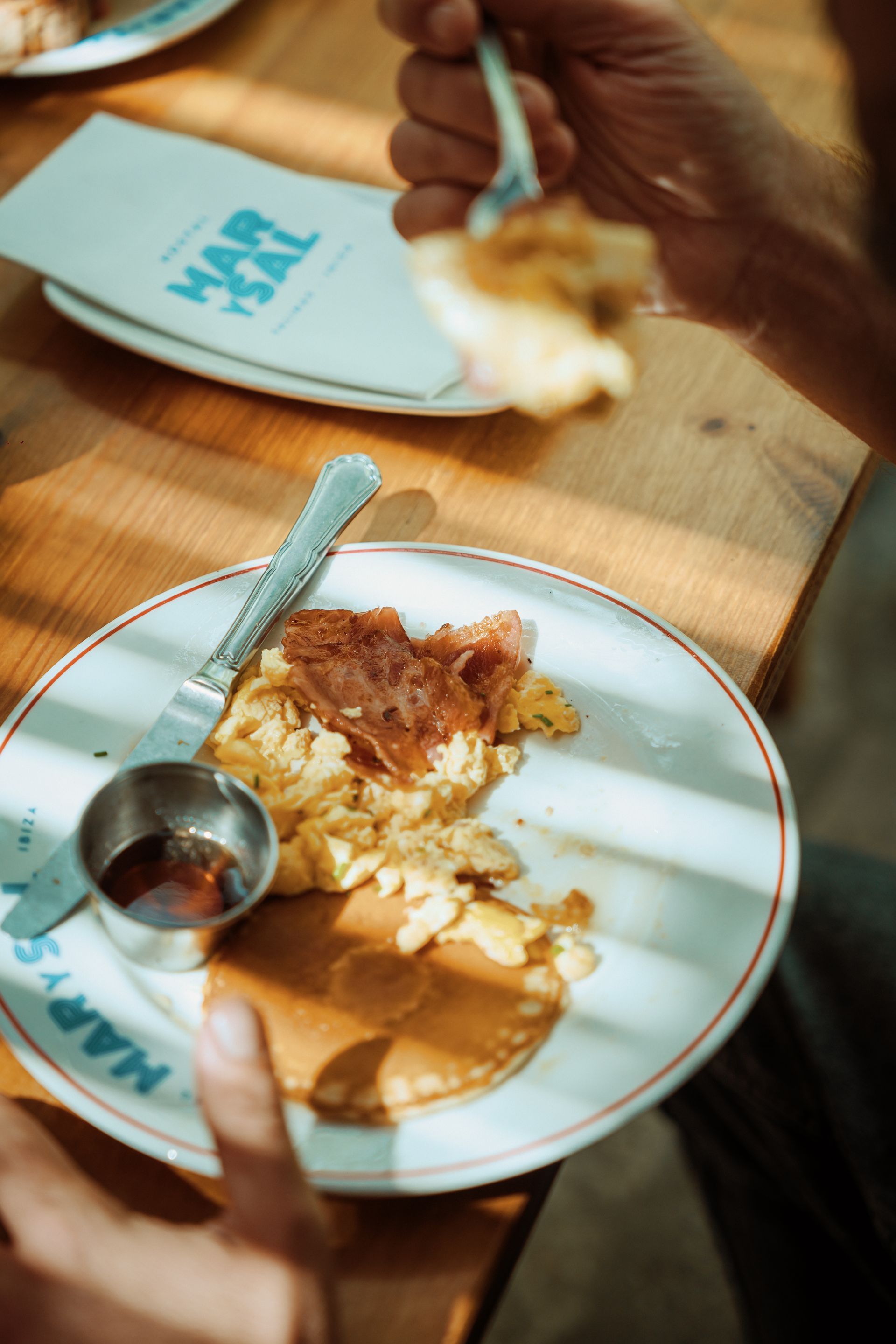 A person is eating a plate of food with a fork.