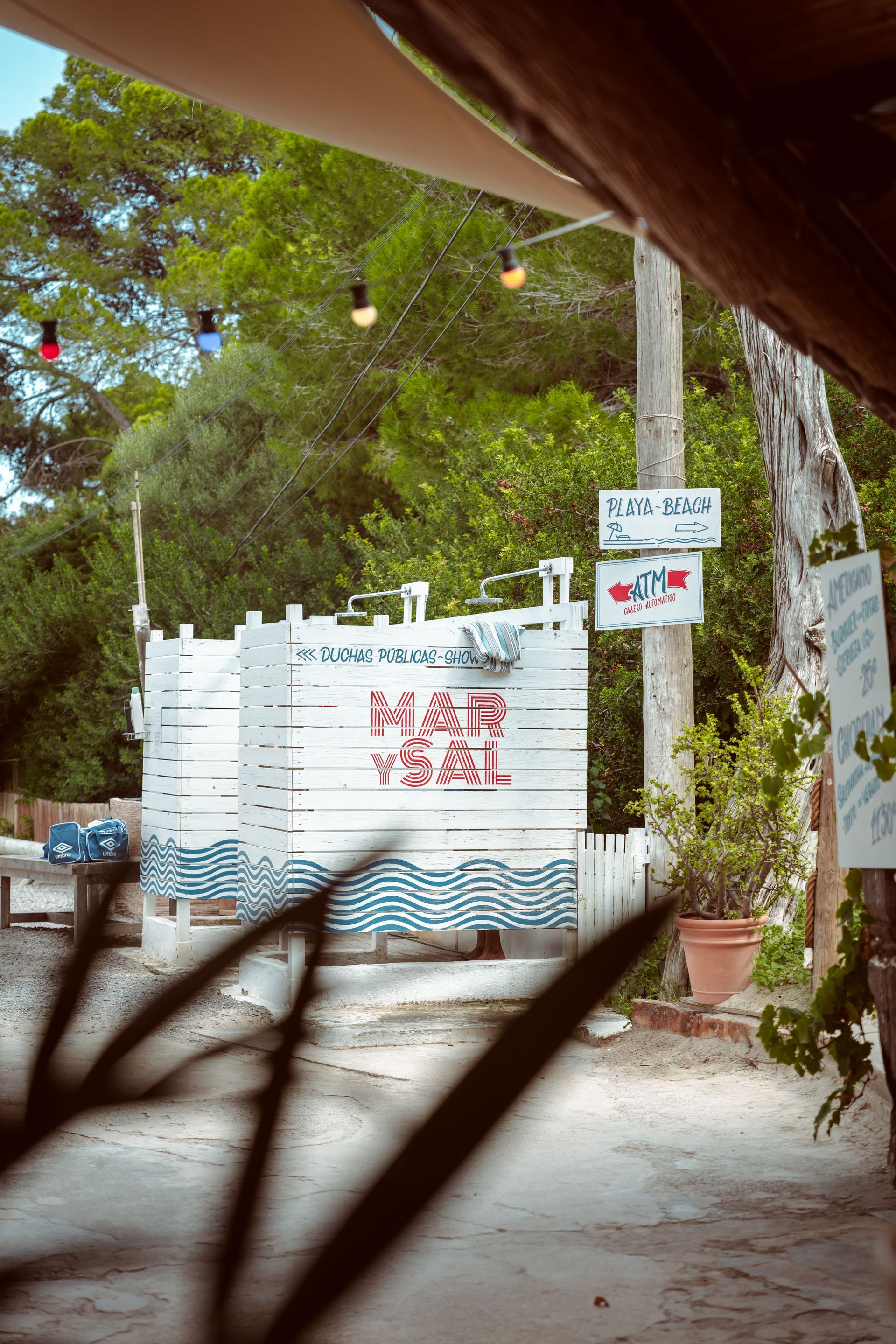 A white wooden fence with a sign on it that says nah we.