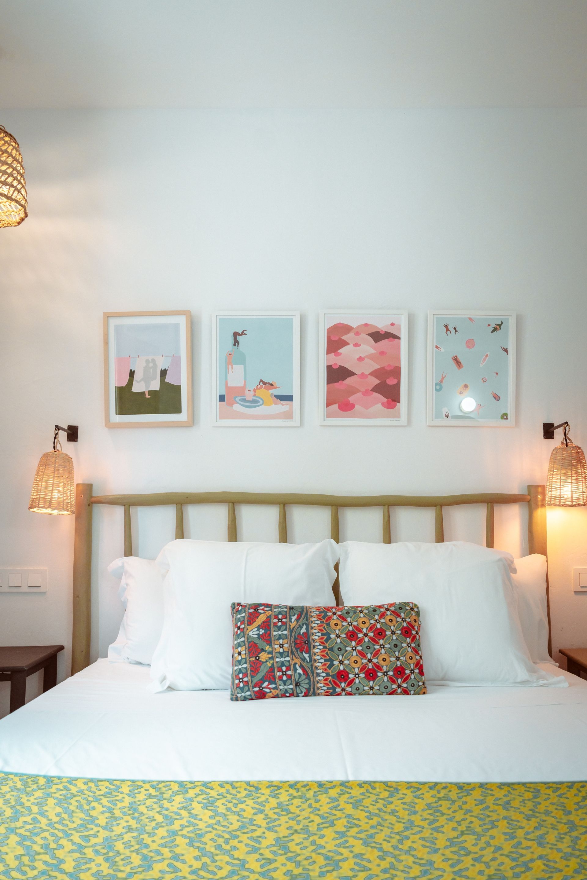 There are three pictures on the wall above the bed.