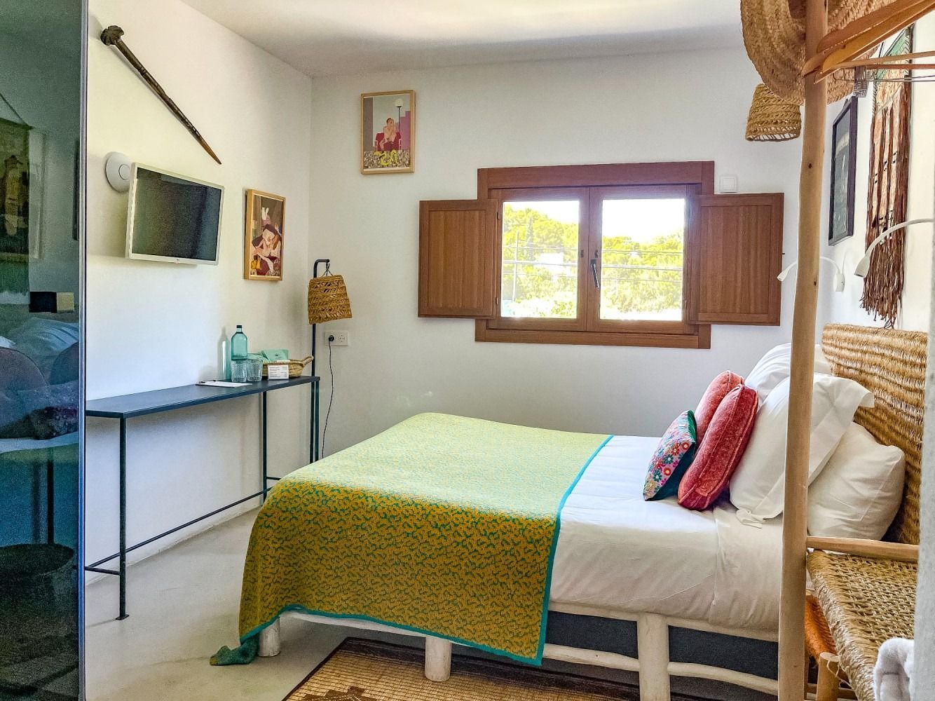 A bedroom with a bed , desk , television and window.