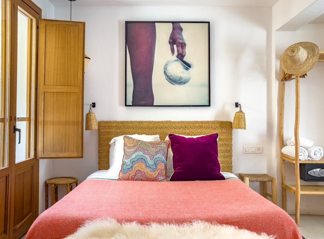 A bedroom with a bed and a painting on the wall above it