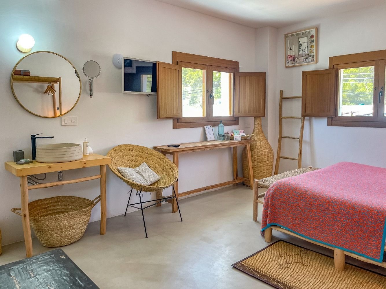 A bedroom with a bed , chair , table and mirror.