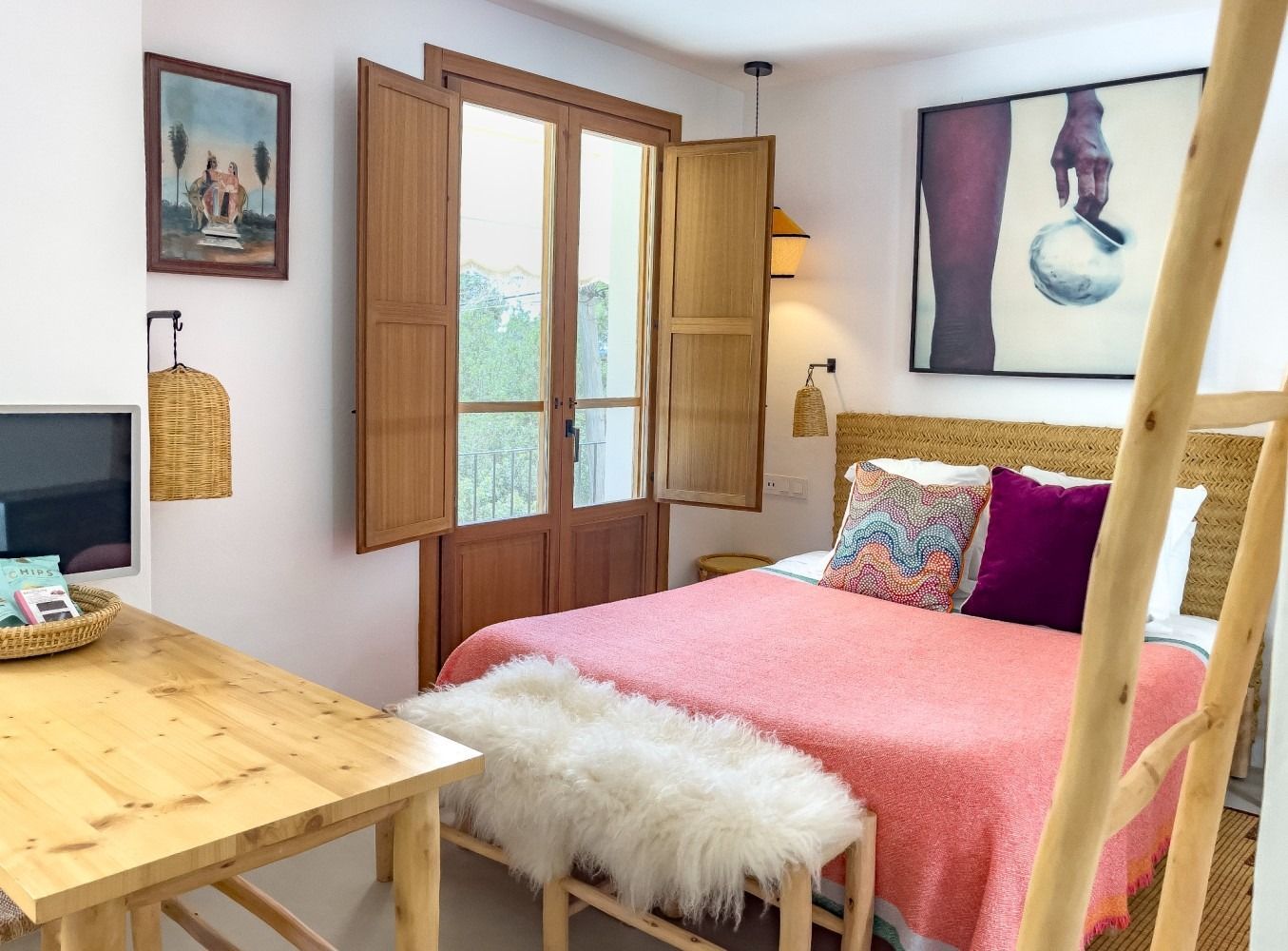 A bedroom with a large bed and a wooden table.