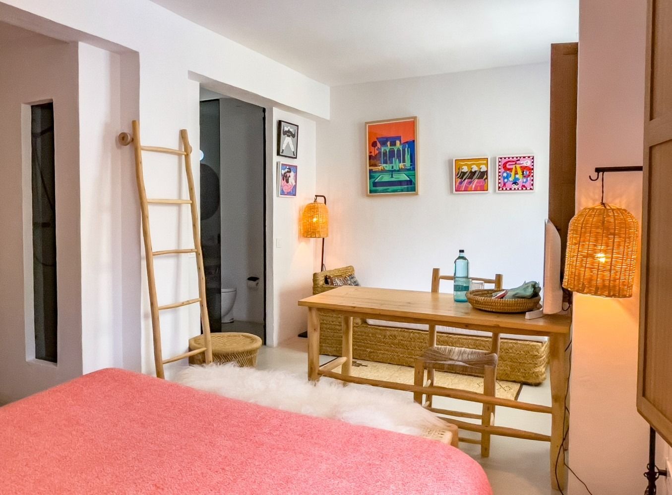 A bedroom with a bed , table , chairs and a ladder.