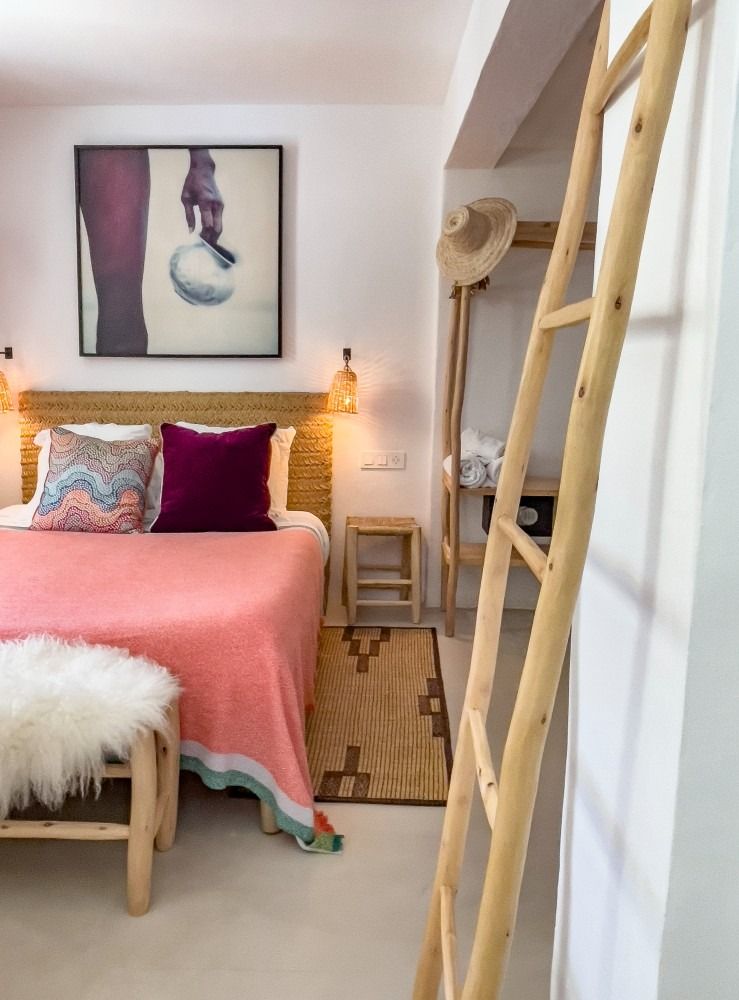 A bedroom with a bed and a ladder hanging on the wall