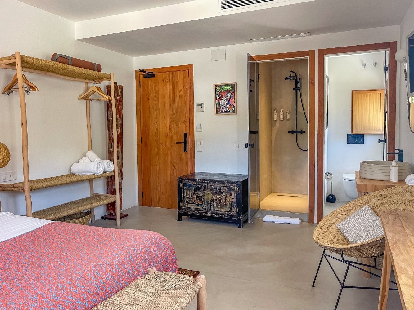 A bedroom with a bed , desk , chair , and shower.