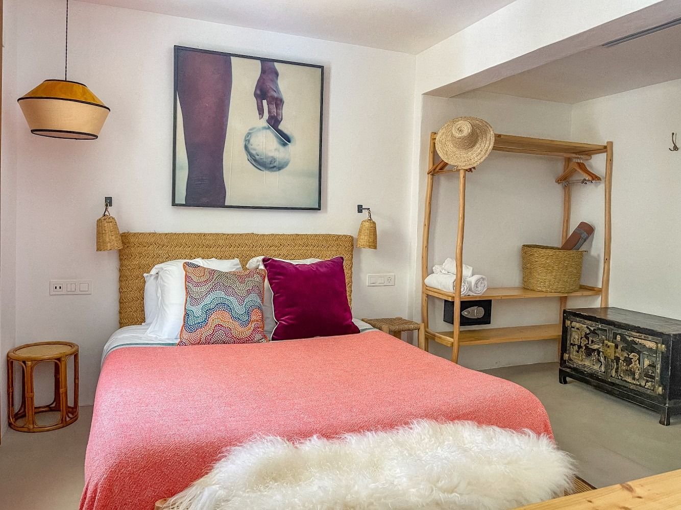 A bedroom with a bed and a painting on the wall.