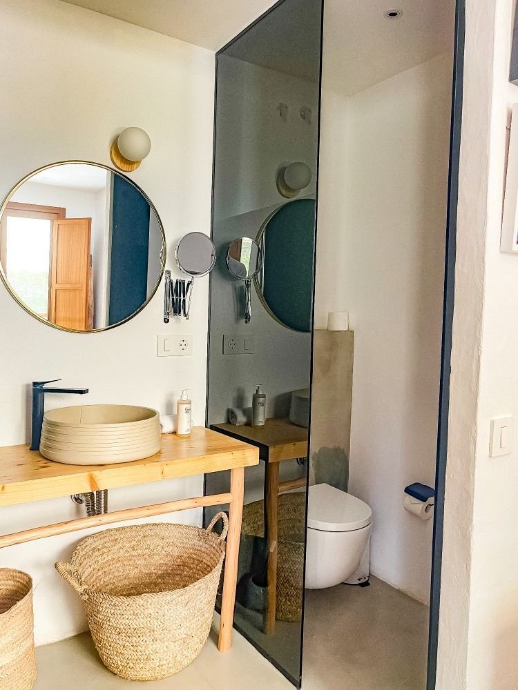 A bathroom with a sink , toilet and mirror.
