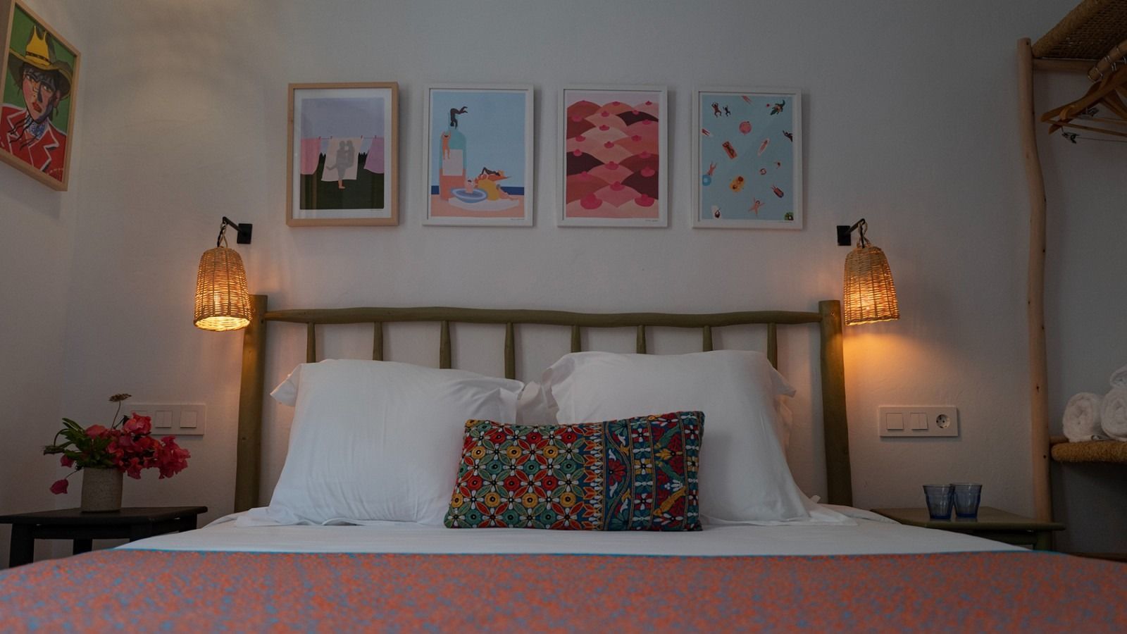 There are three pictures on the wall above the bed.