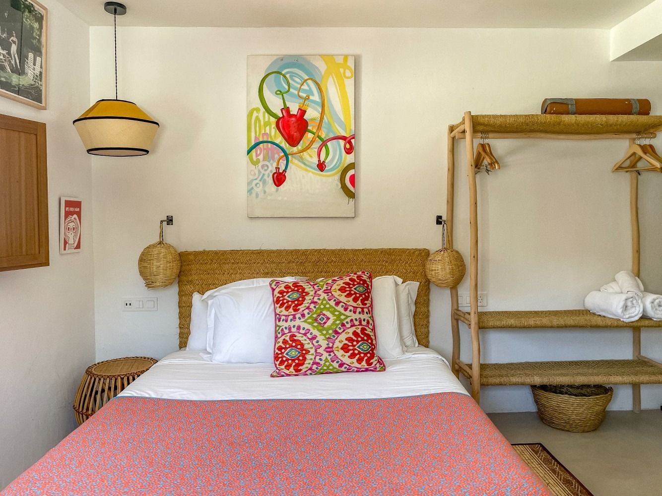 A bedroom with a bed and a painting on the wall.