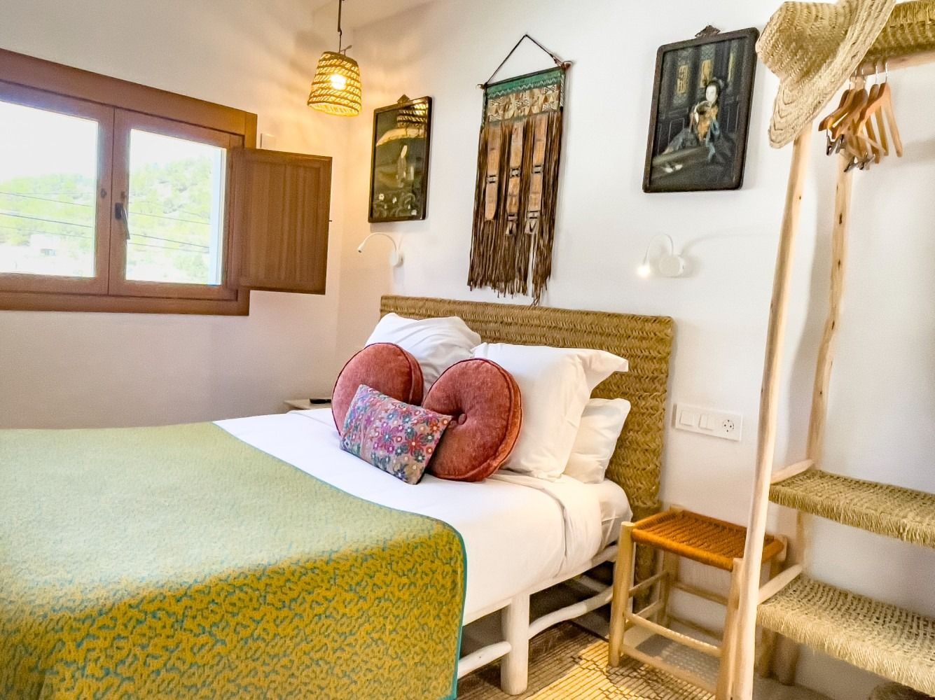 A bedroom with a bed , a chair , a ladder and a window.