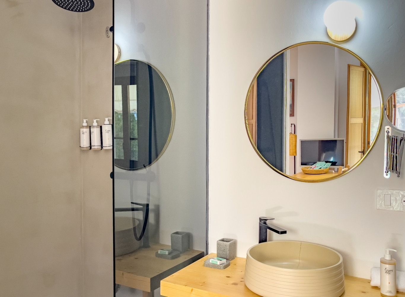 A bathroom with a sink , mirror and shower.