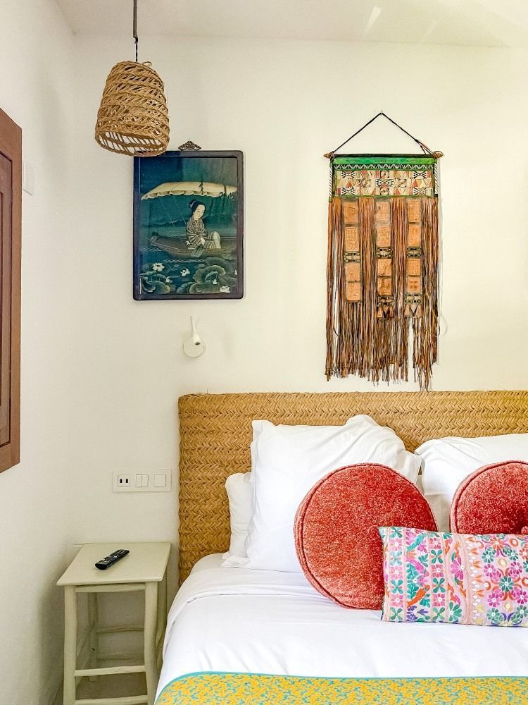 A bedroom with a bed , nightstand , and a painting on the wall.