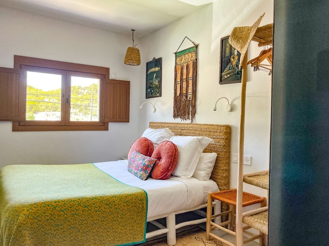A bedroom with a bed , window , chair and stairs.