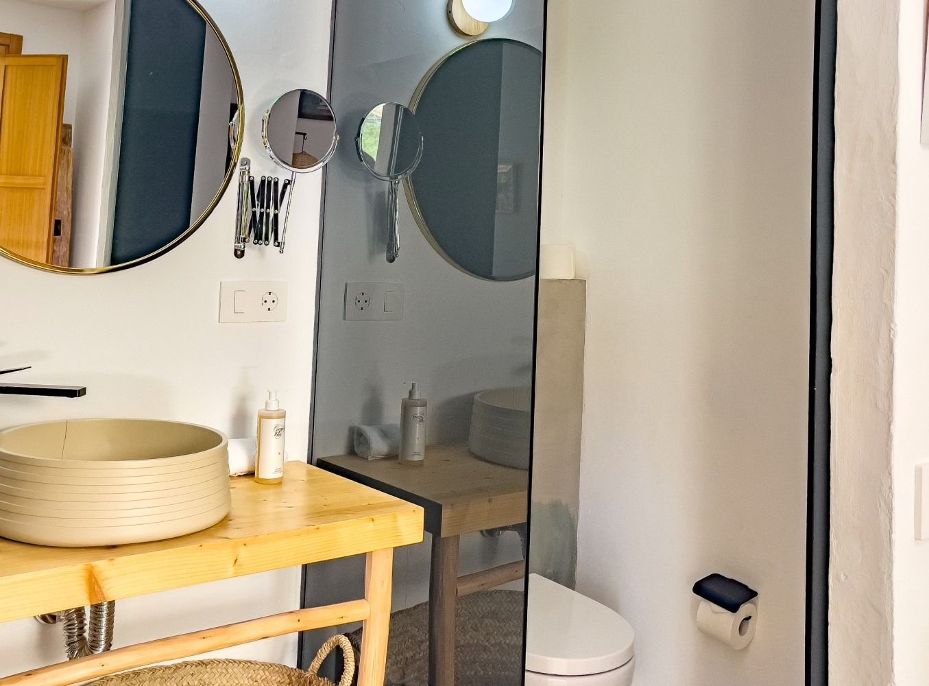 A bathroom with a sink , toilet and mirrors.
