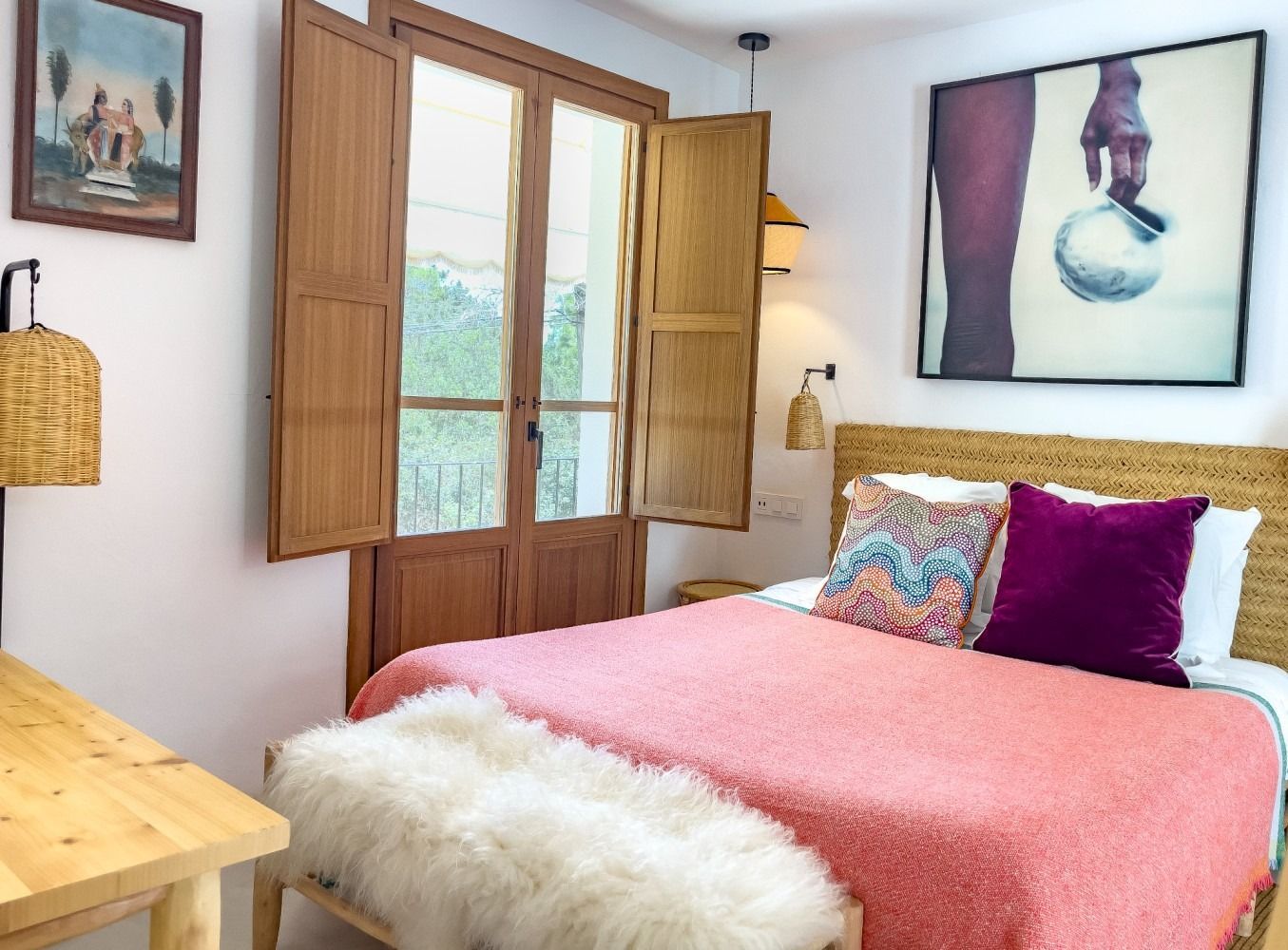 A bedroom with a king size bed and a painting on the wall.