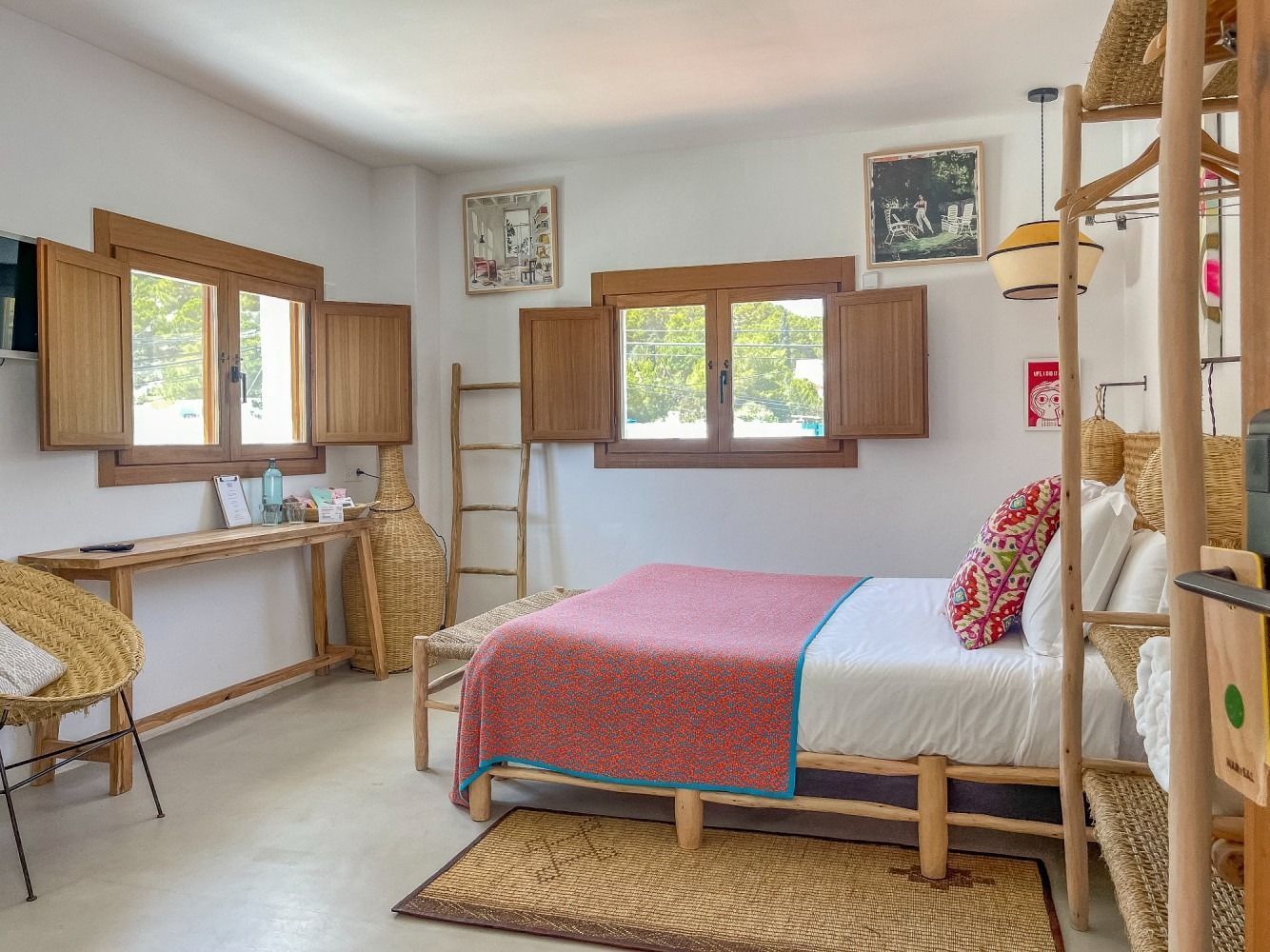 A bedroom with a bed , chair , desk and windows.