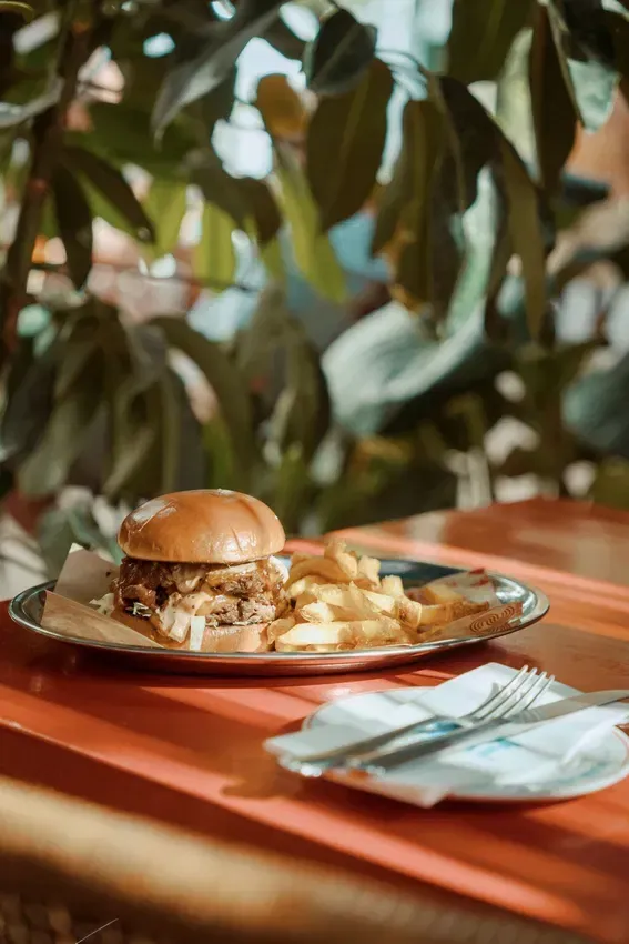 A hamburger and french fries on a plate on a table.