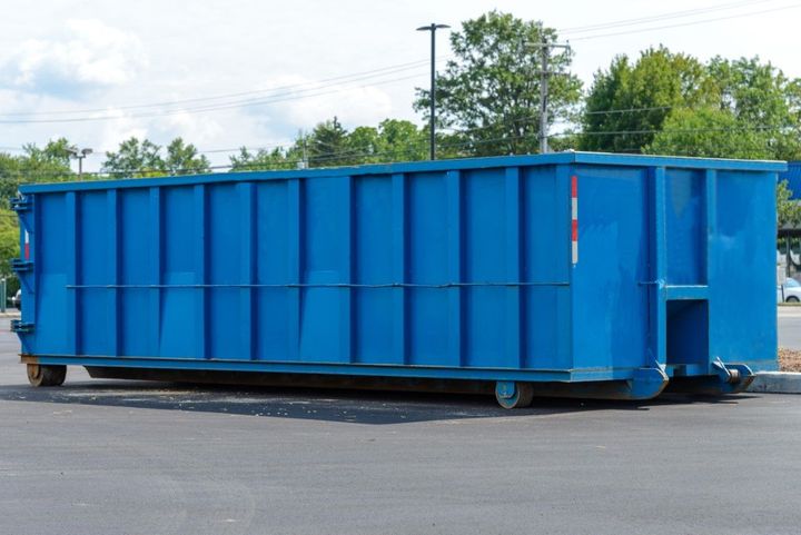 Large blue industrial dumpster on a paved lot outdoors
