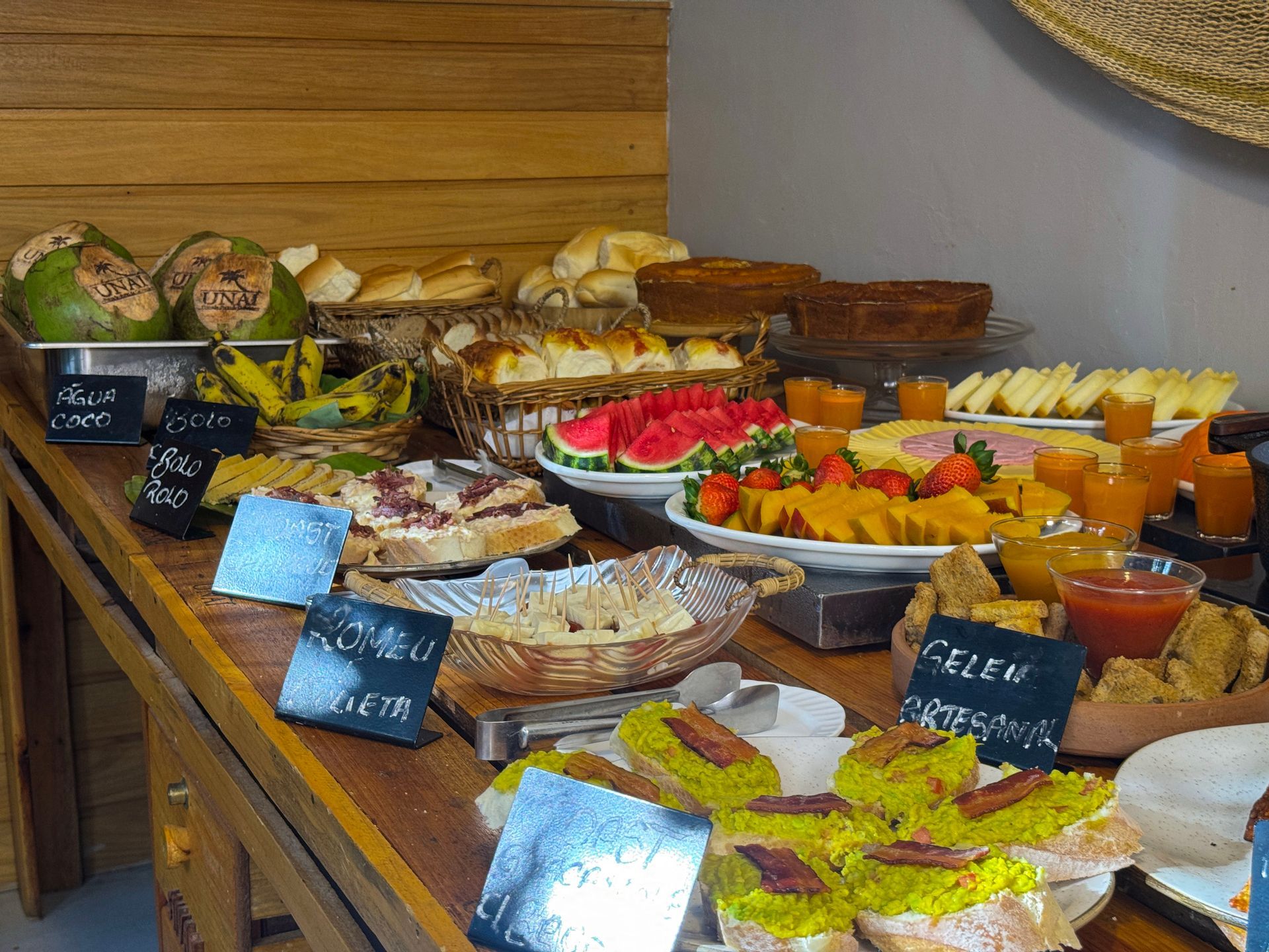 Mesa de buffet com uma variedade de doces, frutas e sobremesas em exposição de café.