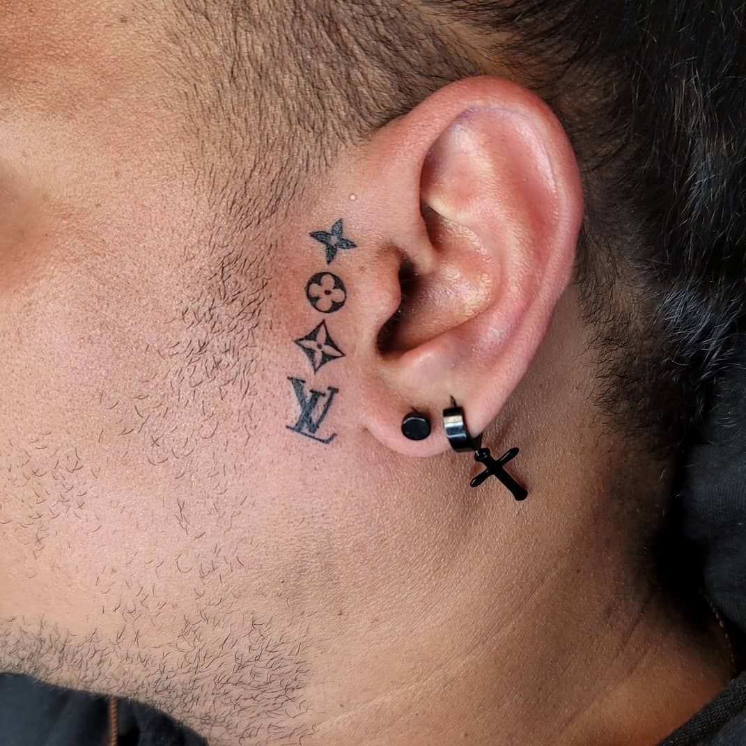 A woman is getting her ear pierced by a piercing artist.