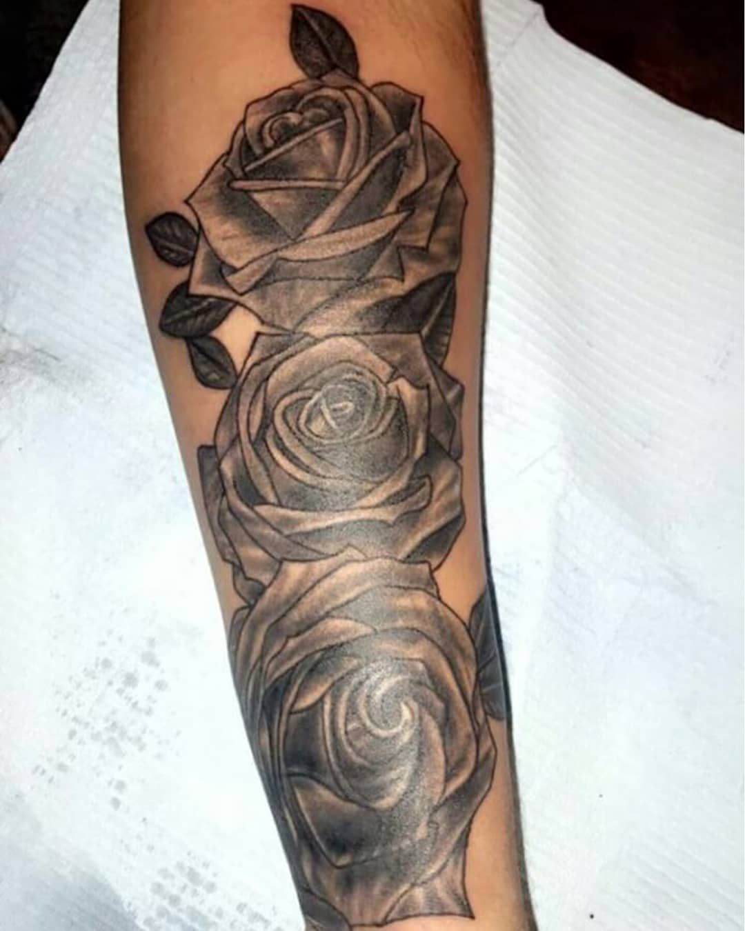 A woman has a tattoo of roses on her back.
