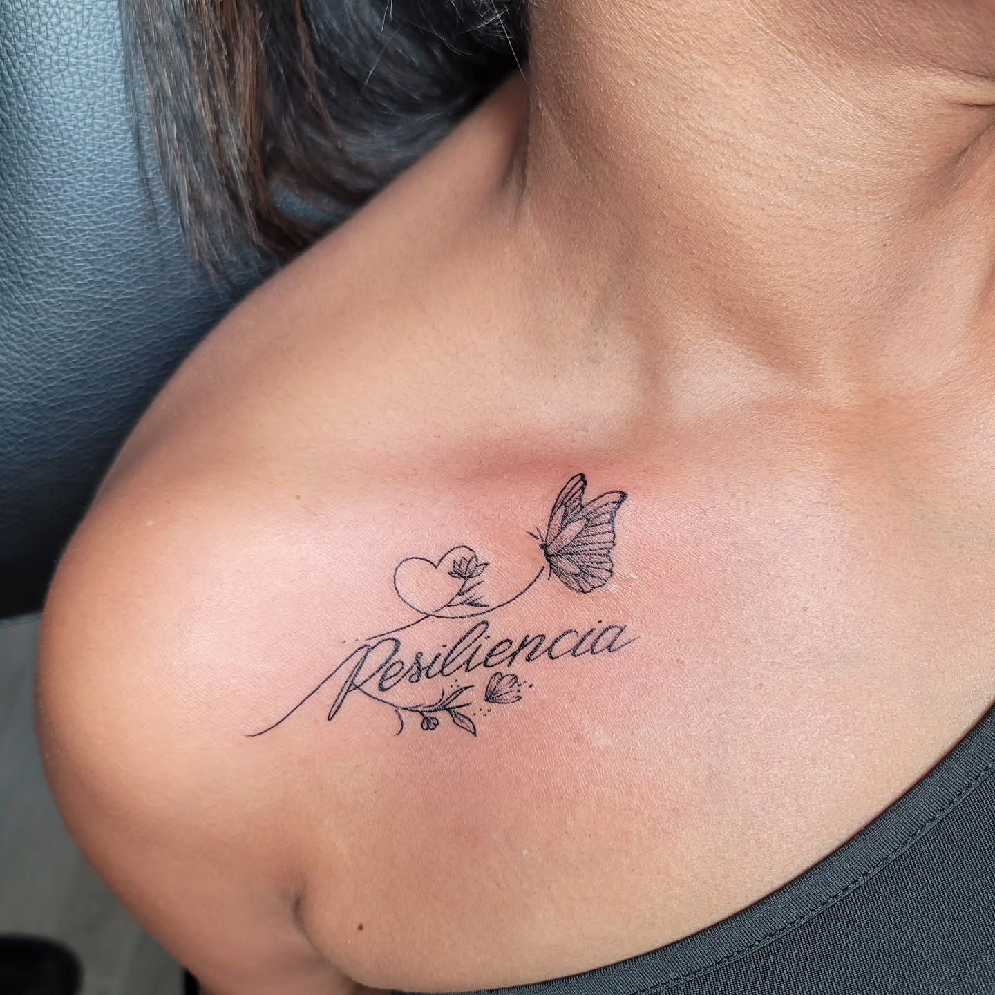 A woman has a tattoo of a heart and butterfly on her arm