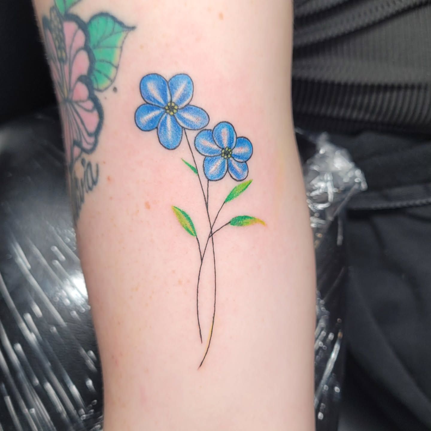 A person is getting a tattoo on their arm.