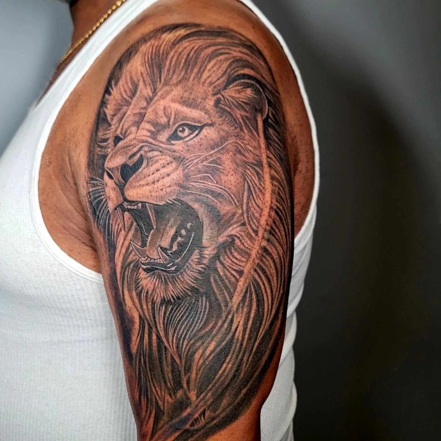 A person is getting a tattoo on their shoulder.