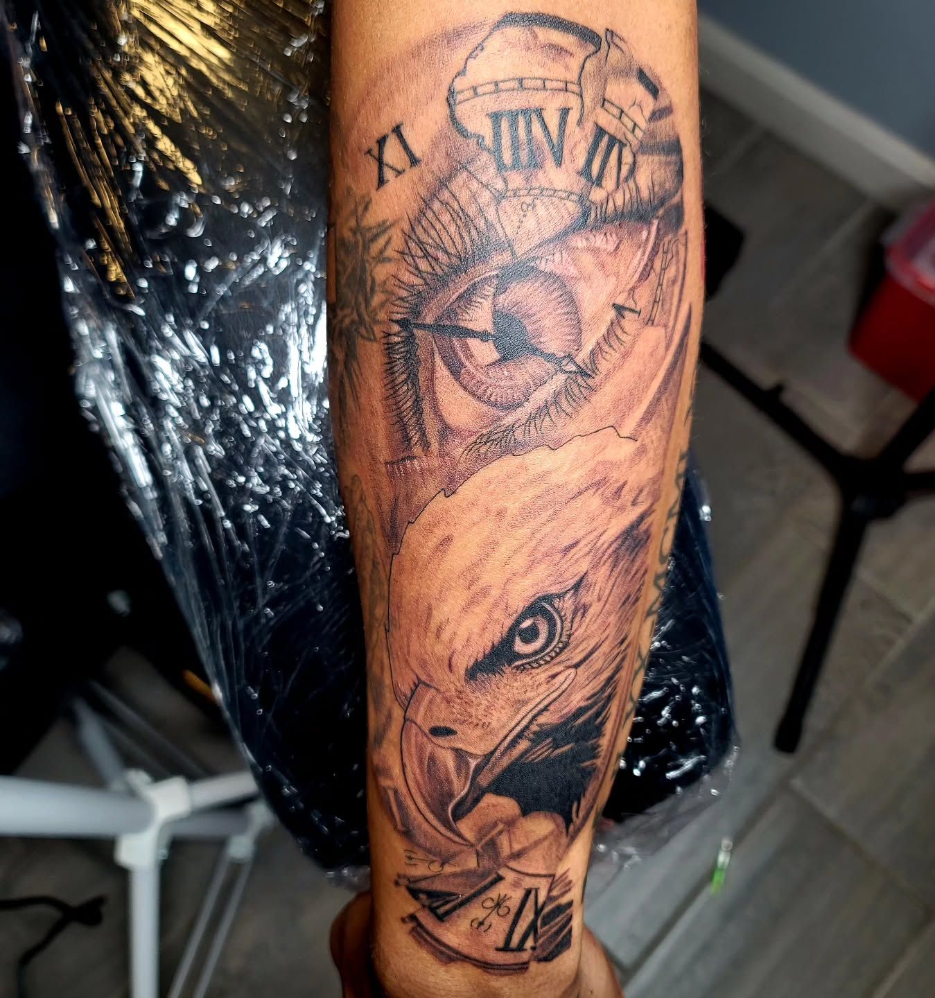 A person with a lot of tattoos on their arm is sitting at a table.
