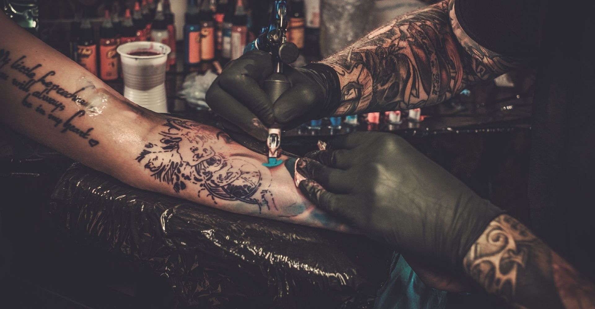 A person is getting a tattoo on their arm.