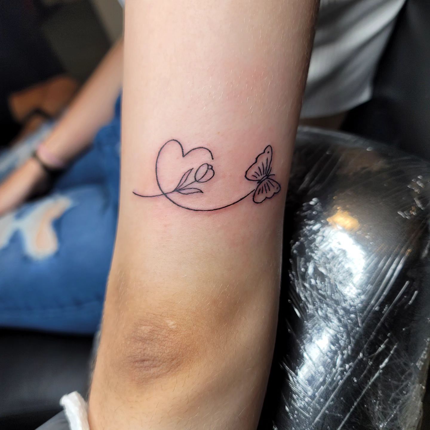 A woman with a tattoo on her arm covering her face.