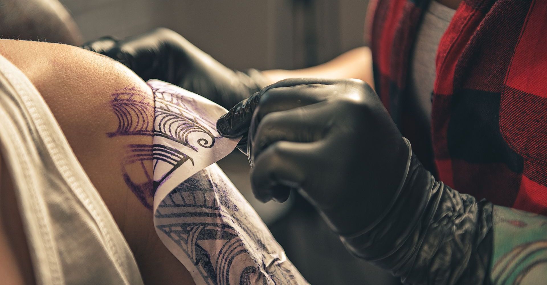 A person is getting a tattoo on their arm.