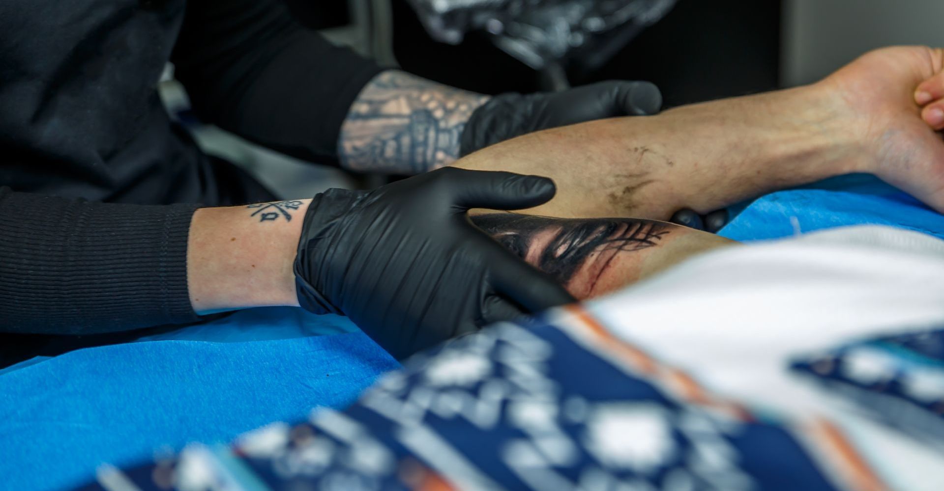 A person is getting a tattoo on their arm.