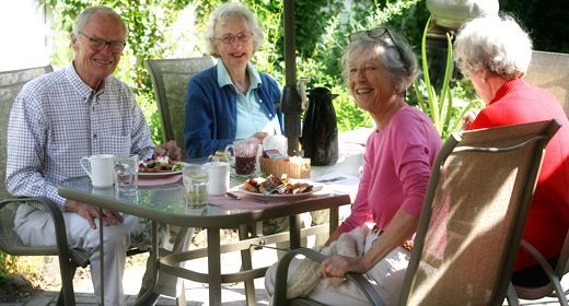 A group of people are sitting at a table with plates of food.