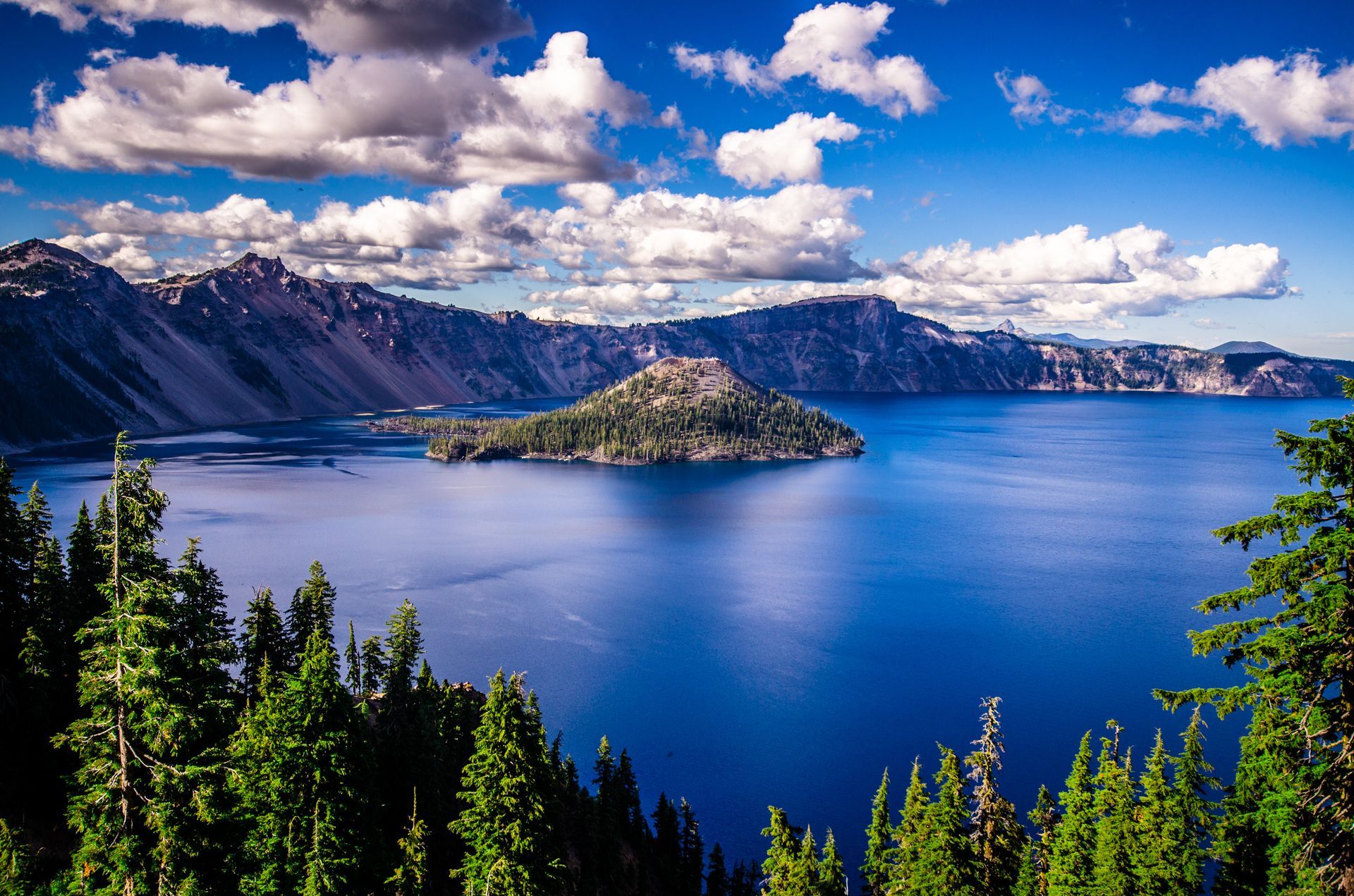 A lake with mountains in the background and a small island in the middle