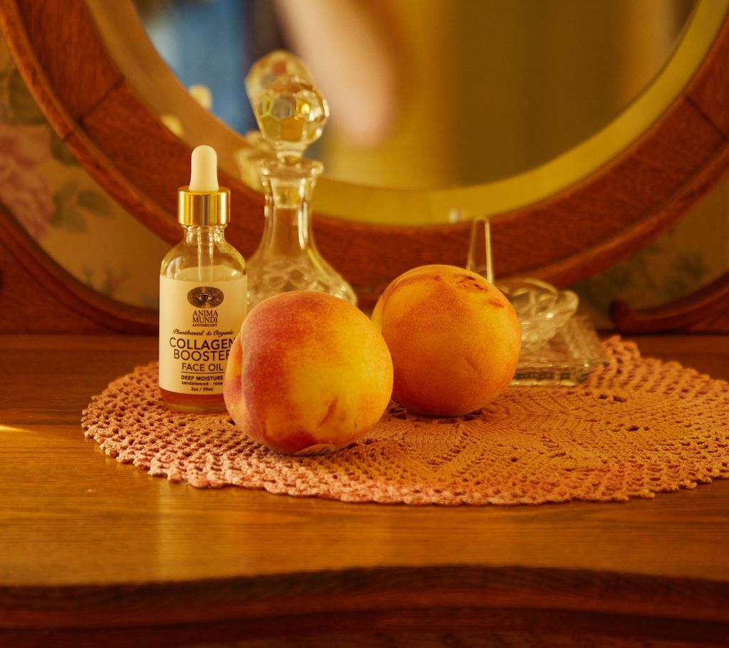 Two peaches sit on a table in front of a mirror