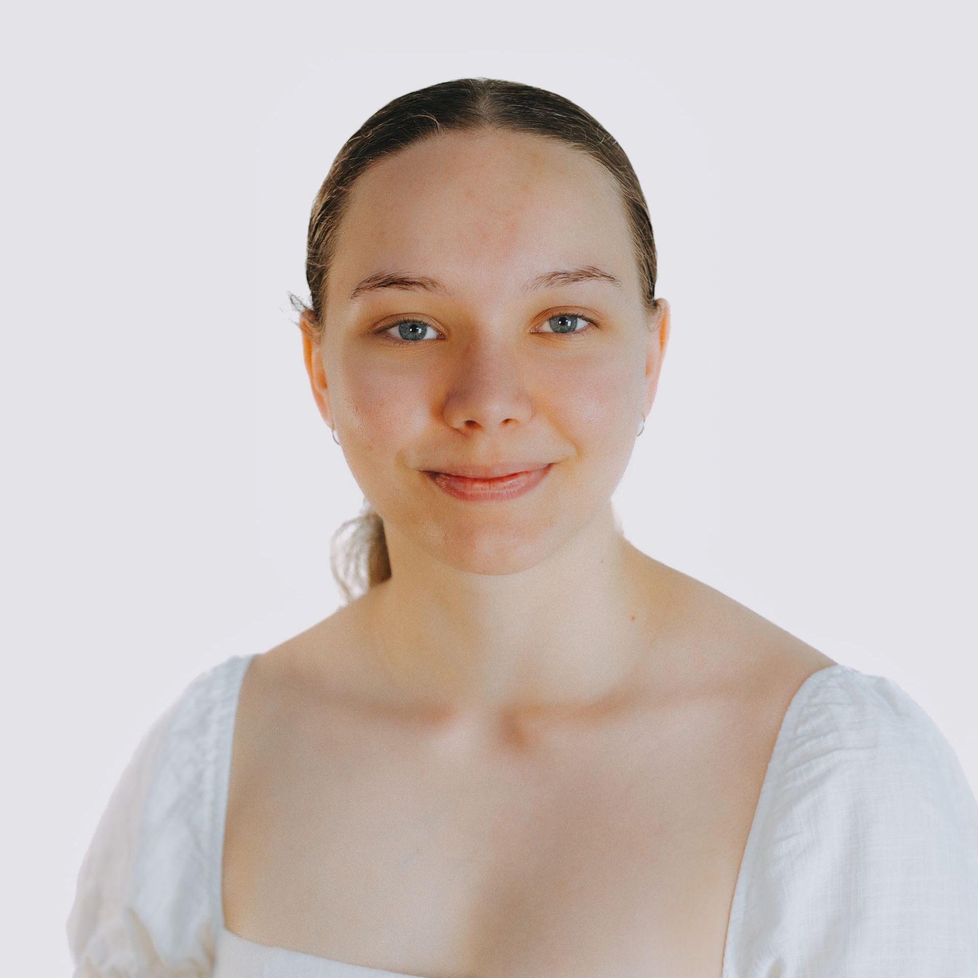 A woman in a white shirt is smiling for the camera.