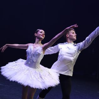 A man and a woman are dancing together on a stage.