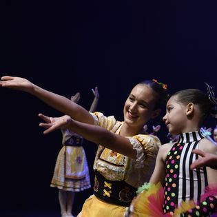 A group of young girls are dancing on a stage.
