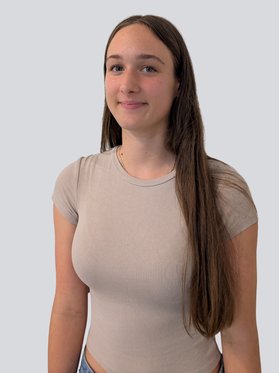 A young woman with long hair is wearing a tan t-shirt and blue jeans.