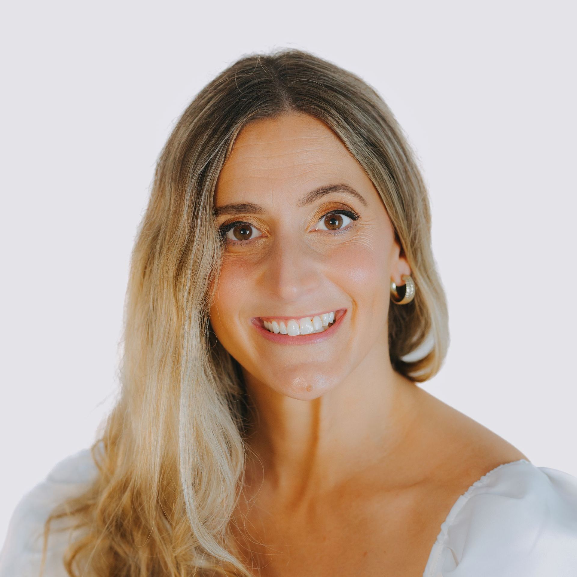 A woman with long blonde hair is smiling for the camera.