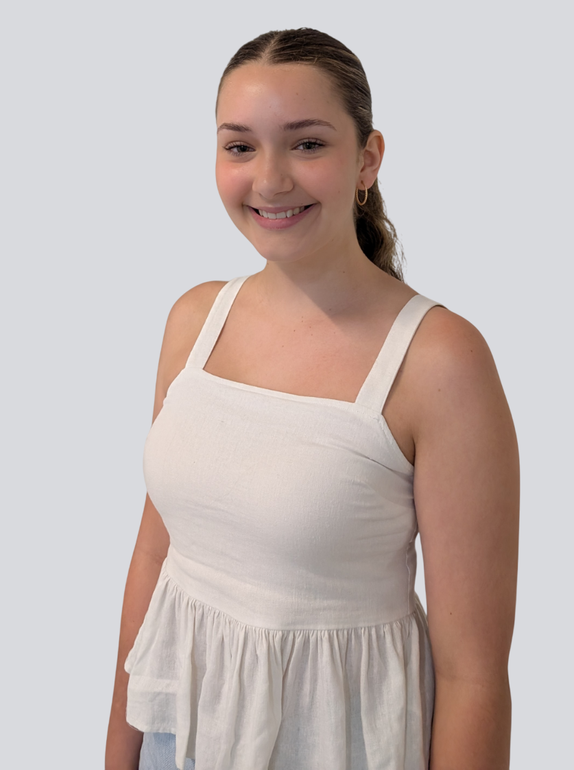 A young woman is wearing a white tank top and smiling.
