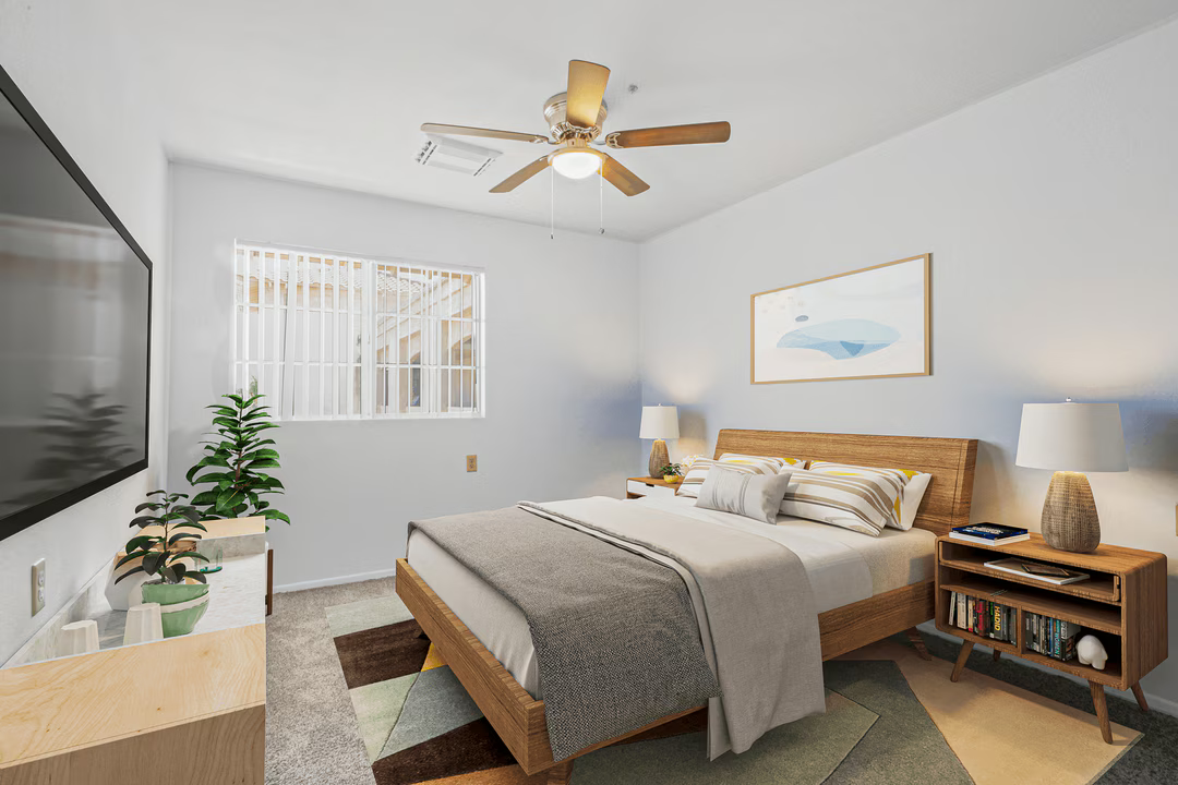 Bright bedroom with a bed, wooden nightstand lamps, ceiling fan, wall art, and a window with blinds